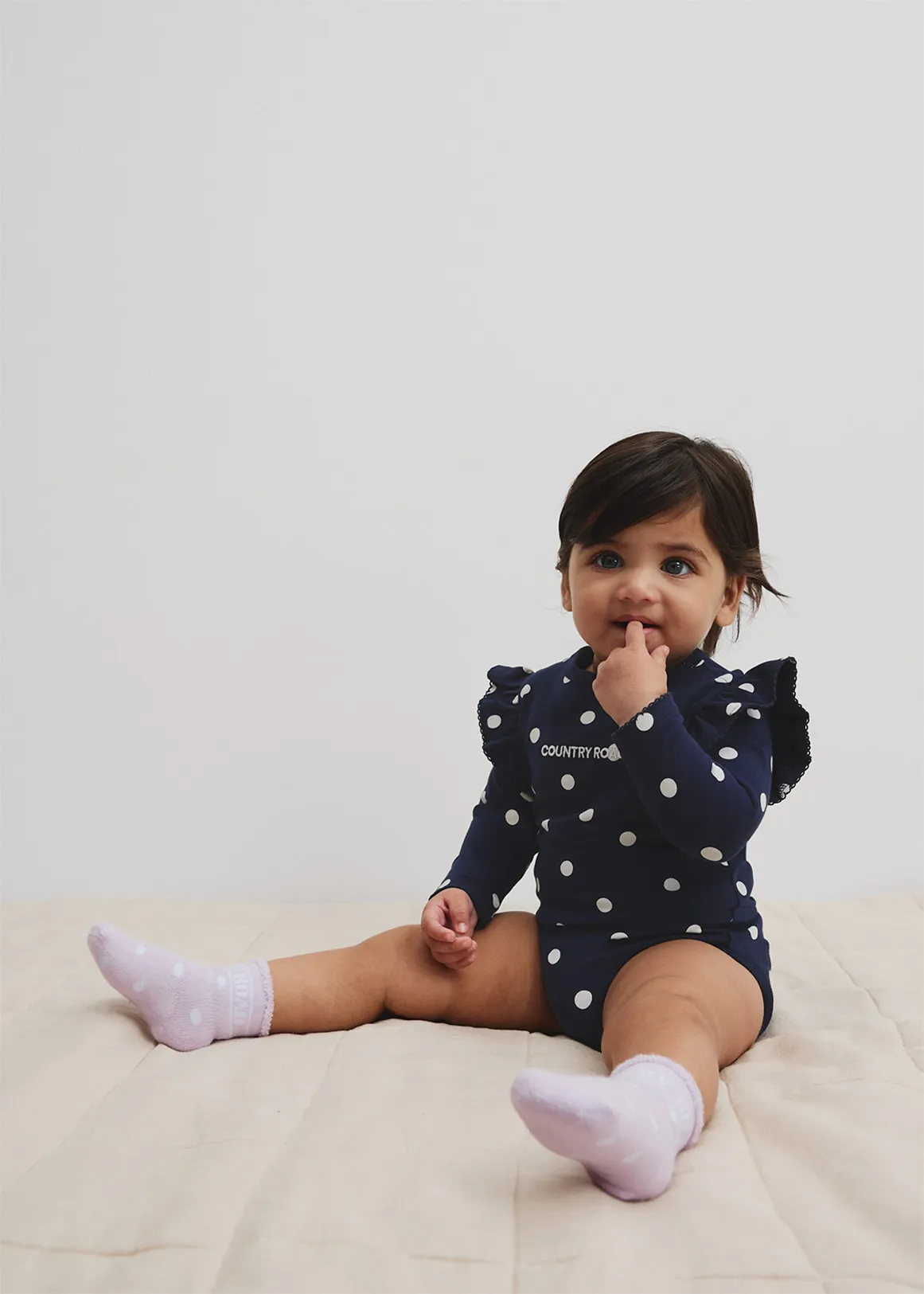 Organically Grown Cotton Blend Frill Long Sleeve Logo Bodysuit - NAVY SPOT